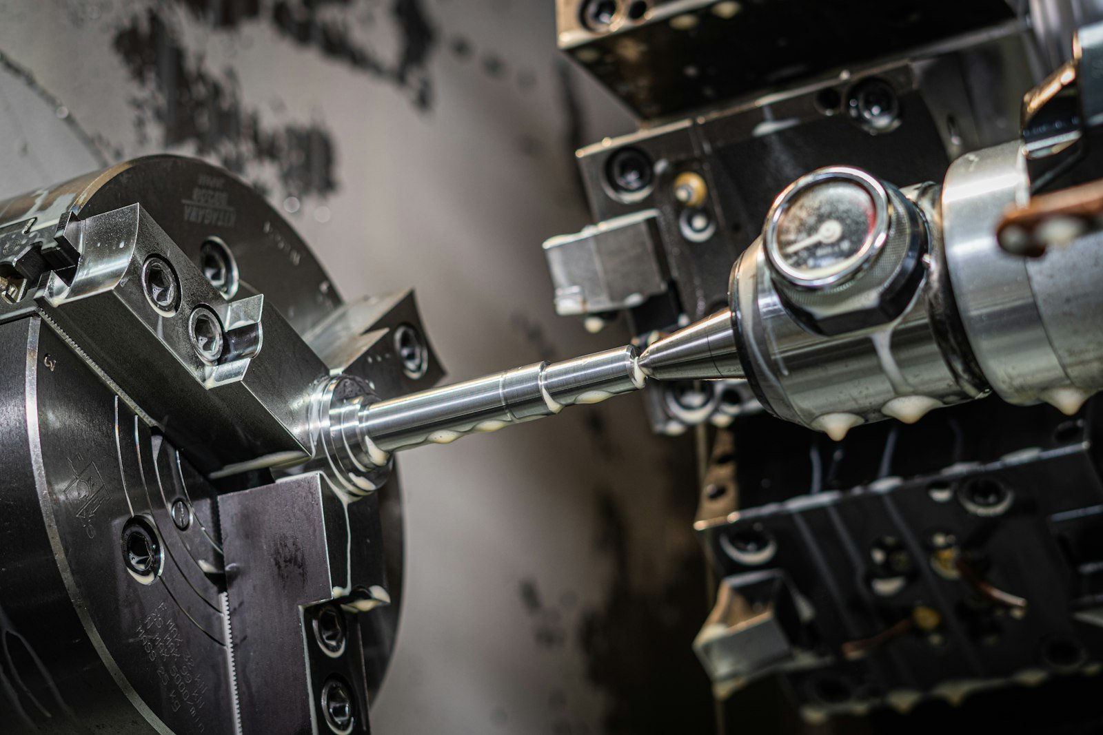 CNC lathe machining a precision steel shaft.